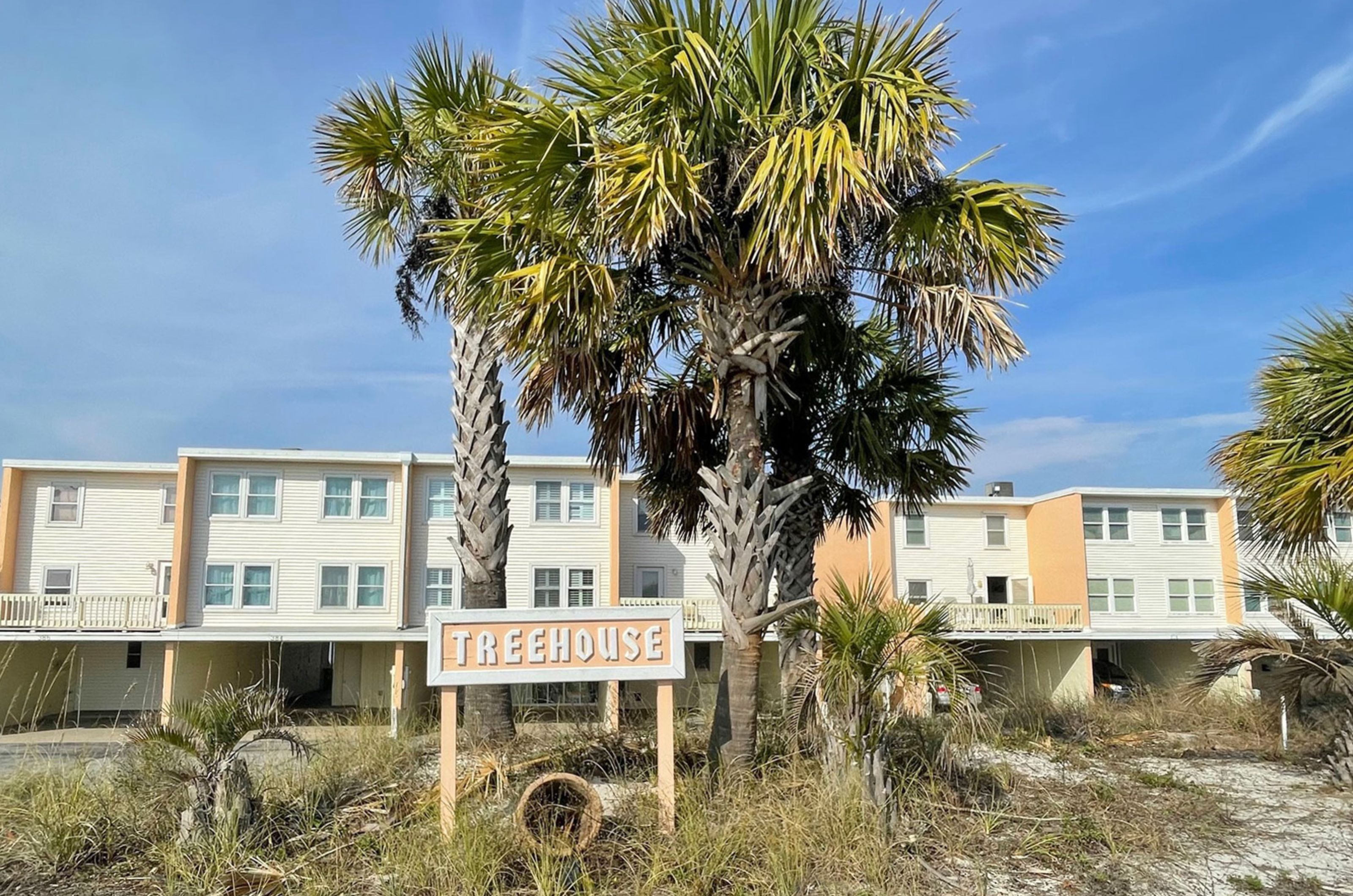 View from the street of the property's sign and exterior at Treehouse Townhomes 