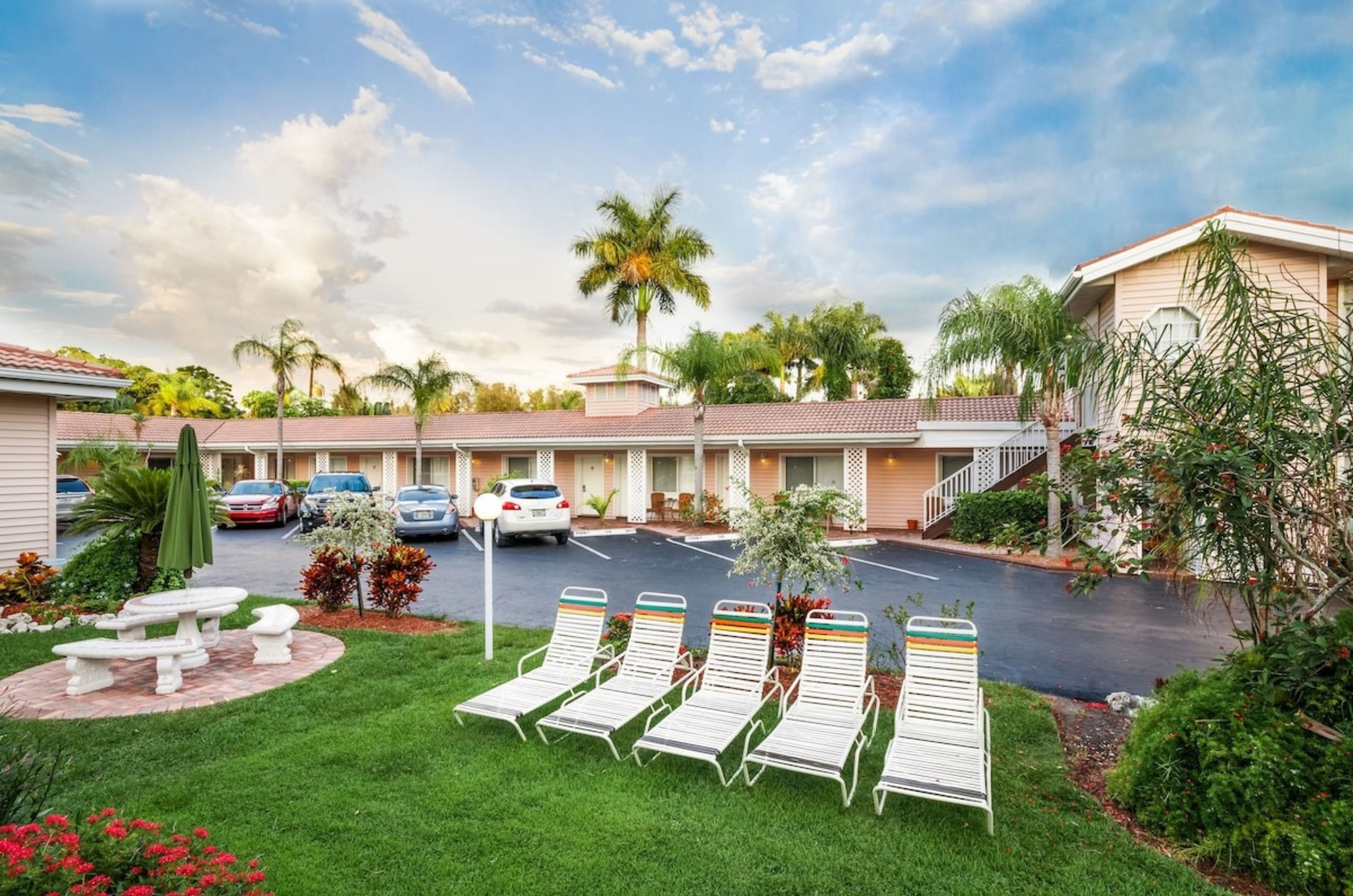 The exterior of Tropical Beach Resorts in Siesta Key Florida with parking and a courtyard in front of the building