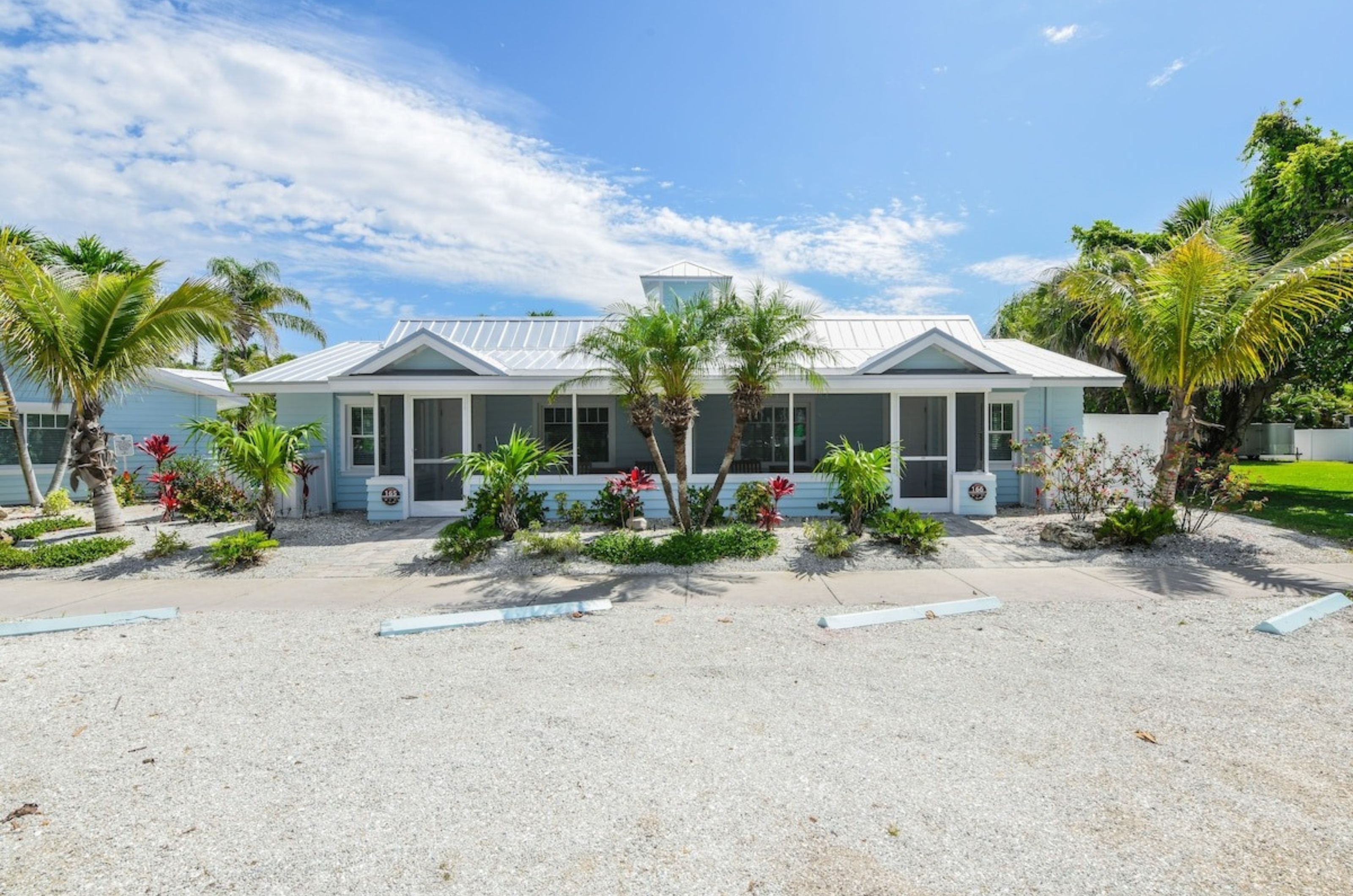 The exterior of Tropical Breeze Resort in Siesta Key Florida with complimentary parking spots out front	