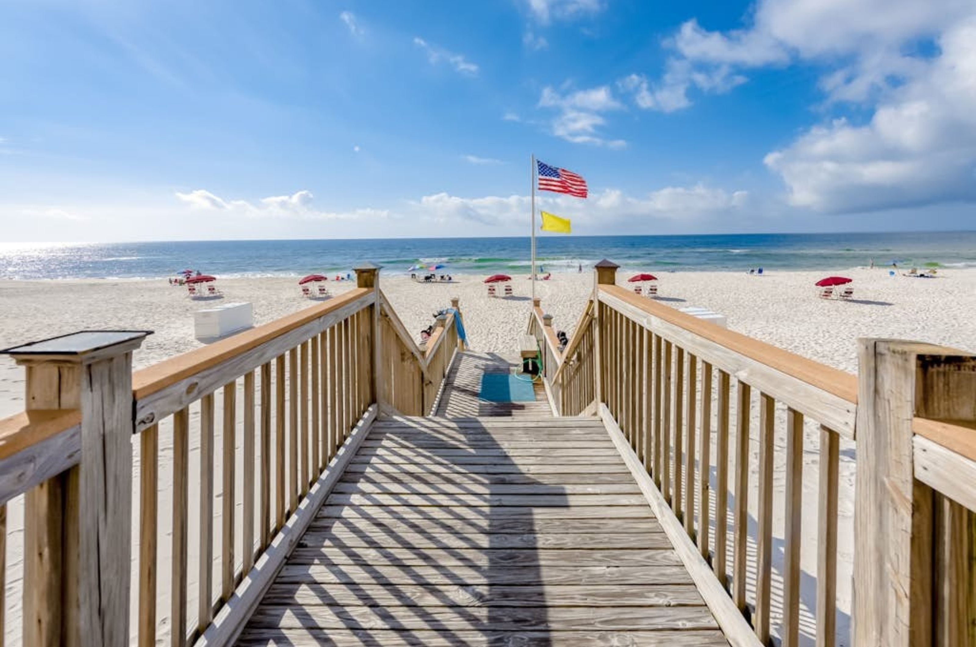 A wooden boardwalk leading to the Gulf and white sandy beach